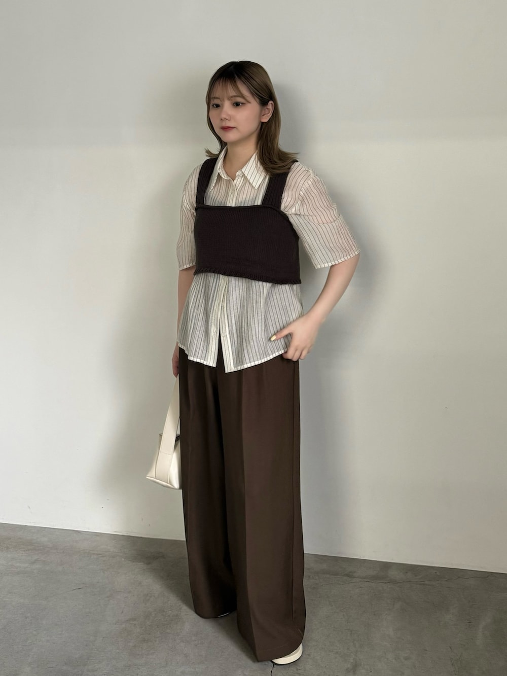 ホワイト系のシャツ/ブラウス、ブラウン系のベスト、ブラック系のキャミソールを着用したレディースの夏コーディネートの3枚目の写真