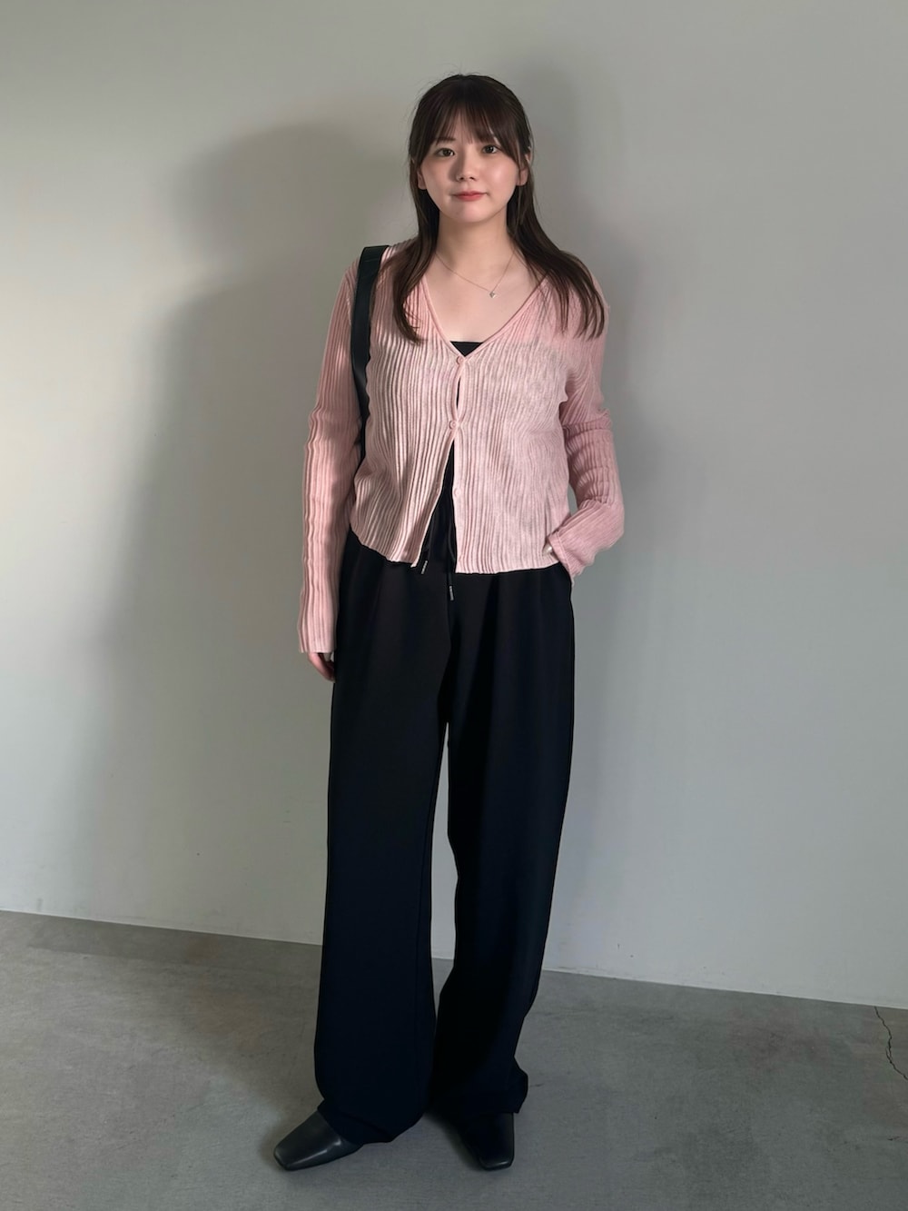 ブラック系のその他パンツ、ブラック系のスリッポン、ピンク系のカーディガン/ボレロを着用したレディースの春コーディネートの3枚目の写真
