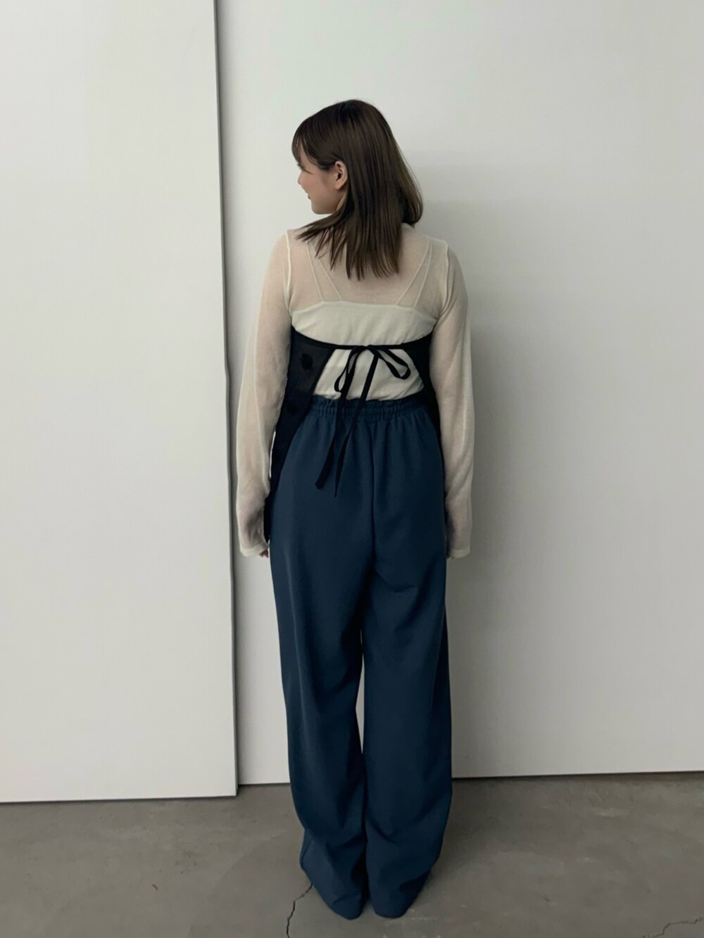 ブラック系のスカート、ホワイト系のニット/セーター、ホワイト系のキャミソールを着用したレディースの夏コーディネートの4枚目の写真