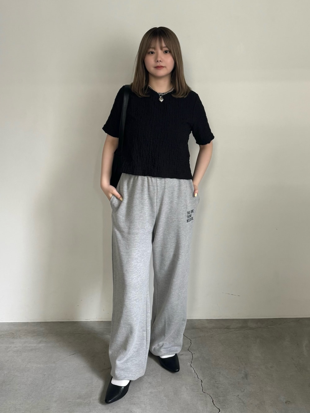 ブラック系のTシャツ/カットソー、グレー系のスウェットパンツ、ブラック系のサンダルを着用したレディースの夏コーディネートの2枚目の写真