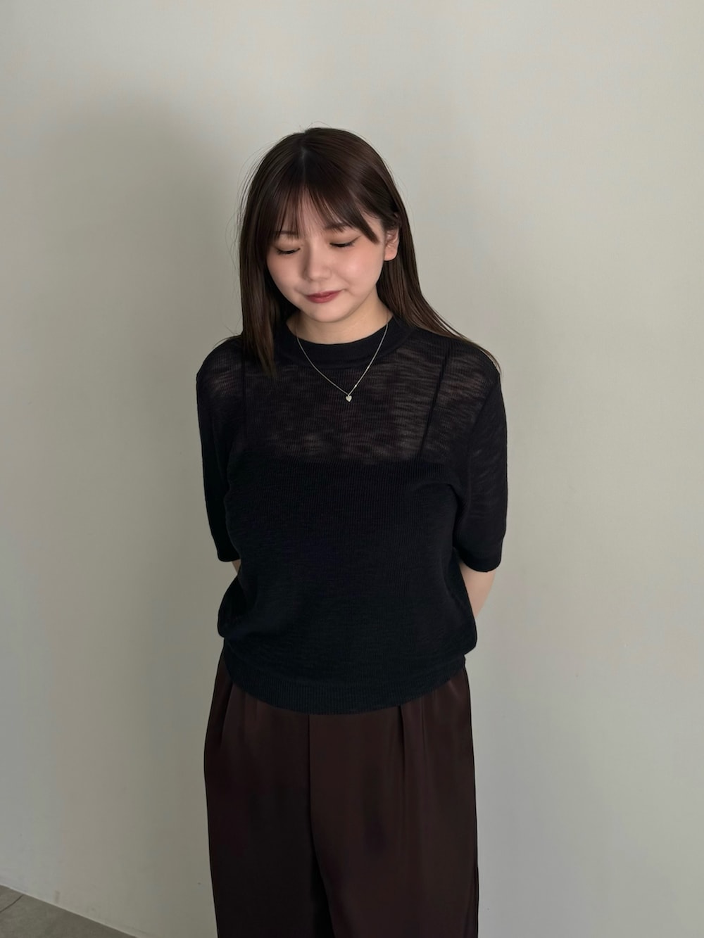 ブラック系のニット/セーター、ブラック系のキャミソール、ブラウン系のその他パンツを着用したレディースの春コーディネートの3枚目の写真