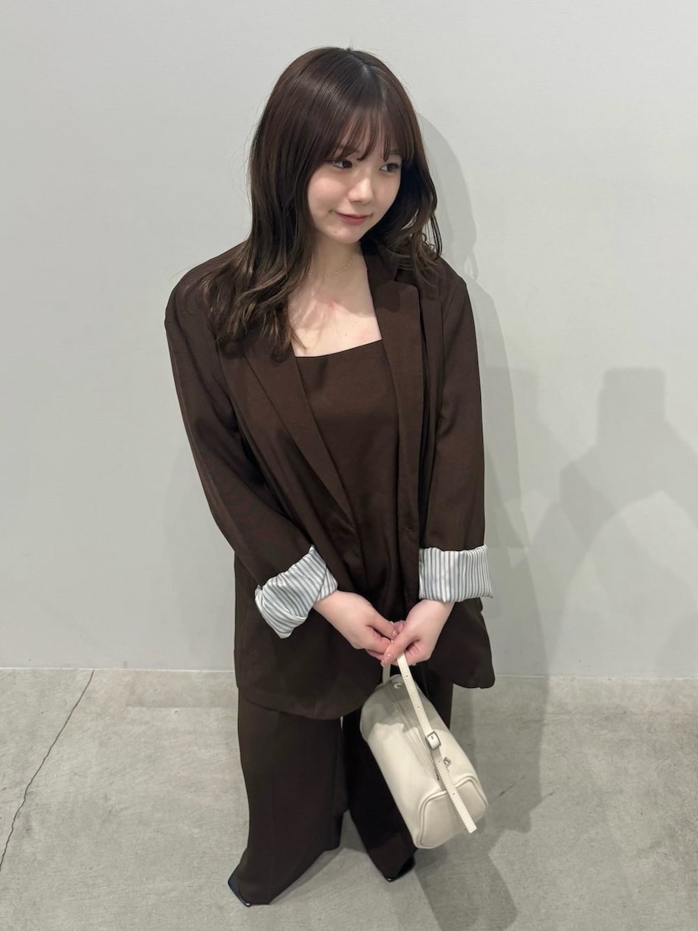 ブラウン系のテーラードジャケット、ブラウン系のキャミソール、ブラウン系のスラックスを着用したレディースの冬コーディネートの5枚目の写真