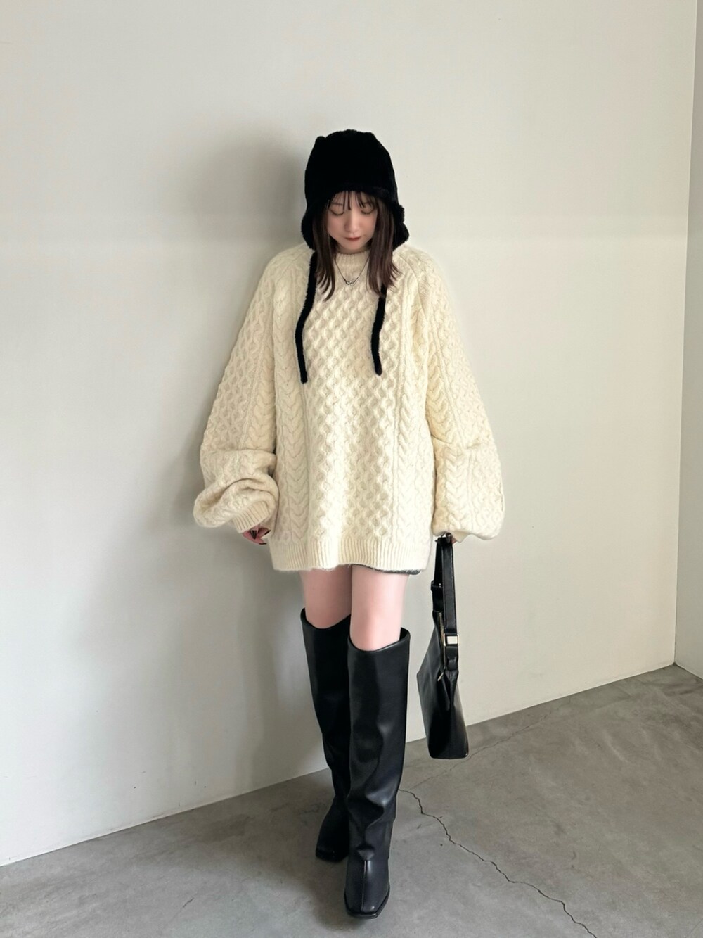 ホワイト系のニット/セーター、グレー系のその他パンツ、ブラック系のハンドバッグを着用したレディースの秋コーディネートの3枚目の写真