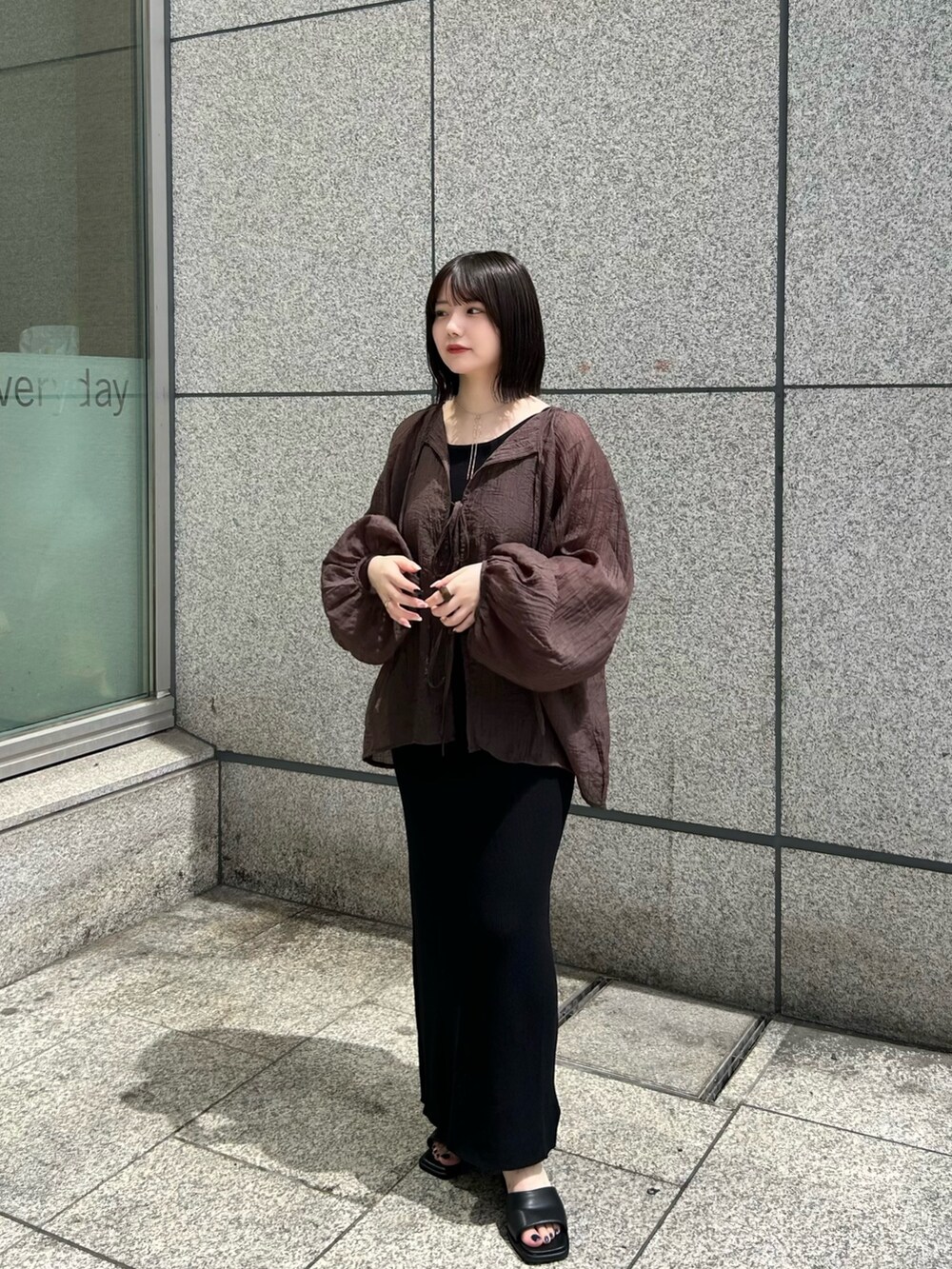 ブラウン系のシャツ/ブラウス、ブラック系のワンピース、ブラック系のサンダルを着用したレディースの夏コーディネートの2枚目の写真