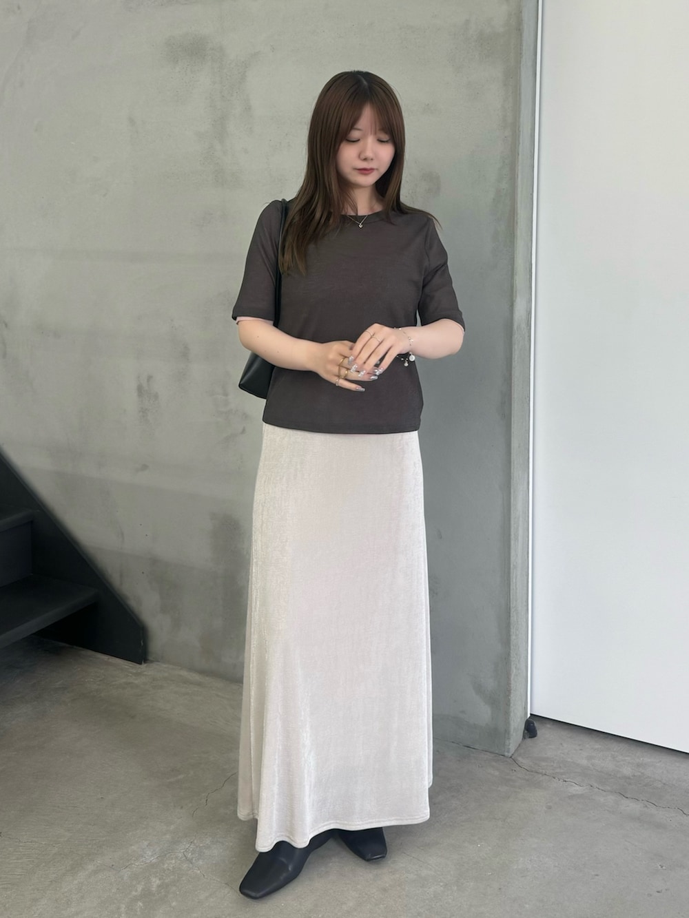 グレー系のTシャツ/カットソー、ホワイト系のスカート、ブラック系のスリッポンを着用したレディースの夏コーディネートの2枚目の写真