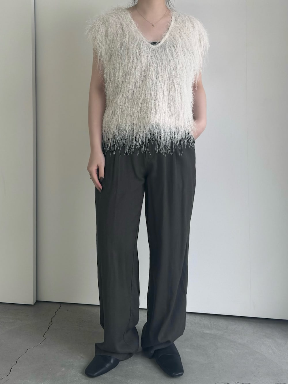 ベージュ系のベスト、ブラック系のキャミソール、グレー系のその他パンツを着用したレディースの春コーディネートの2枚目の写真