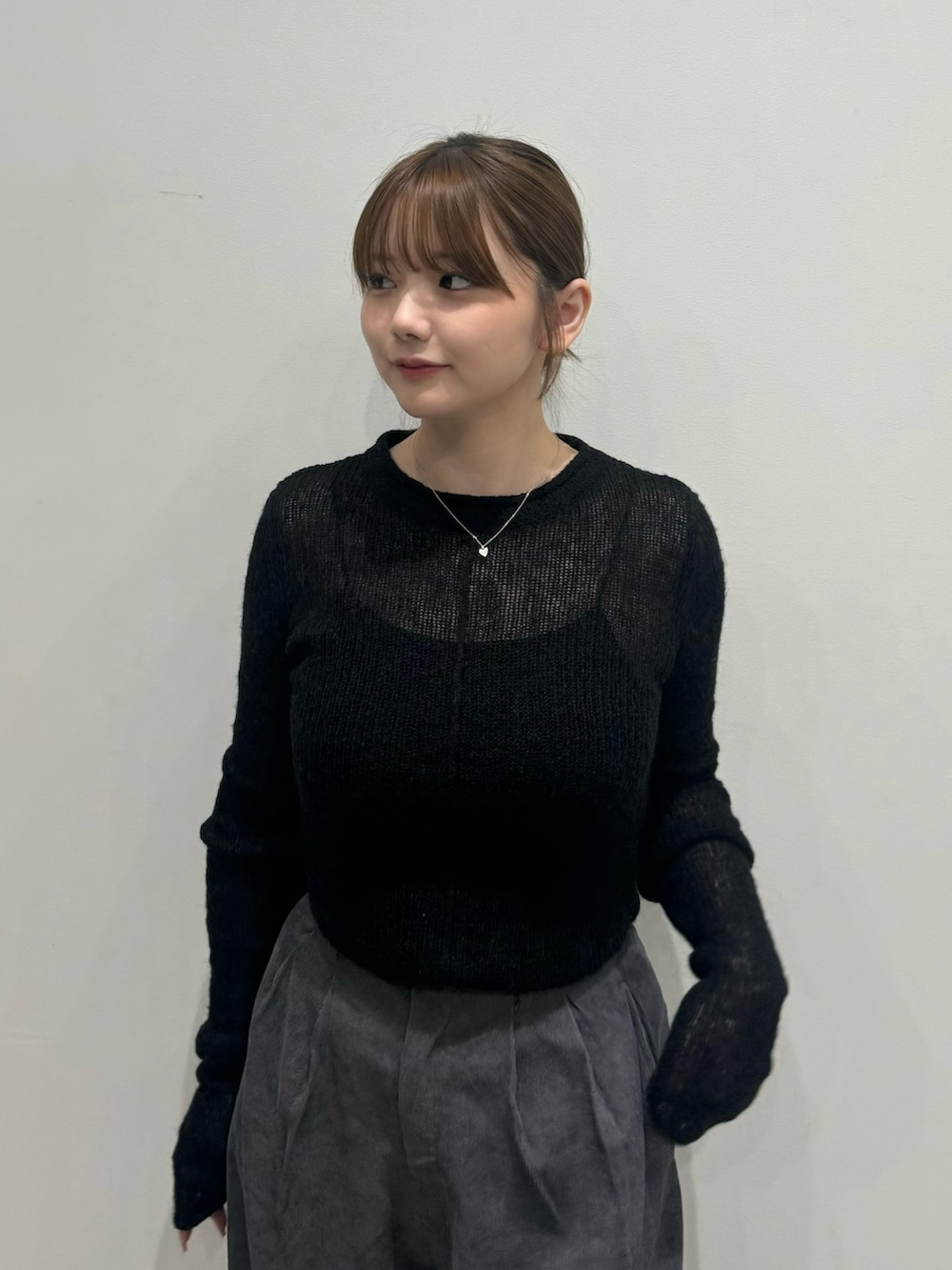 ブラック系のニット/セーター、ブラック系のキャミソール、グレー系のスラックスを着用したレディースの夏コーディネートの4枚目の写真
