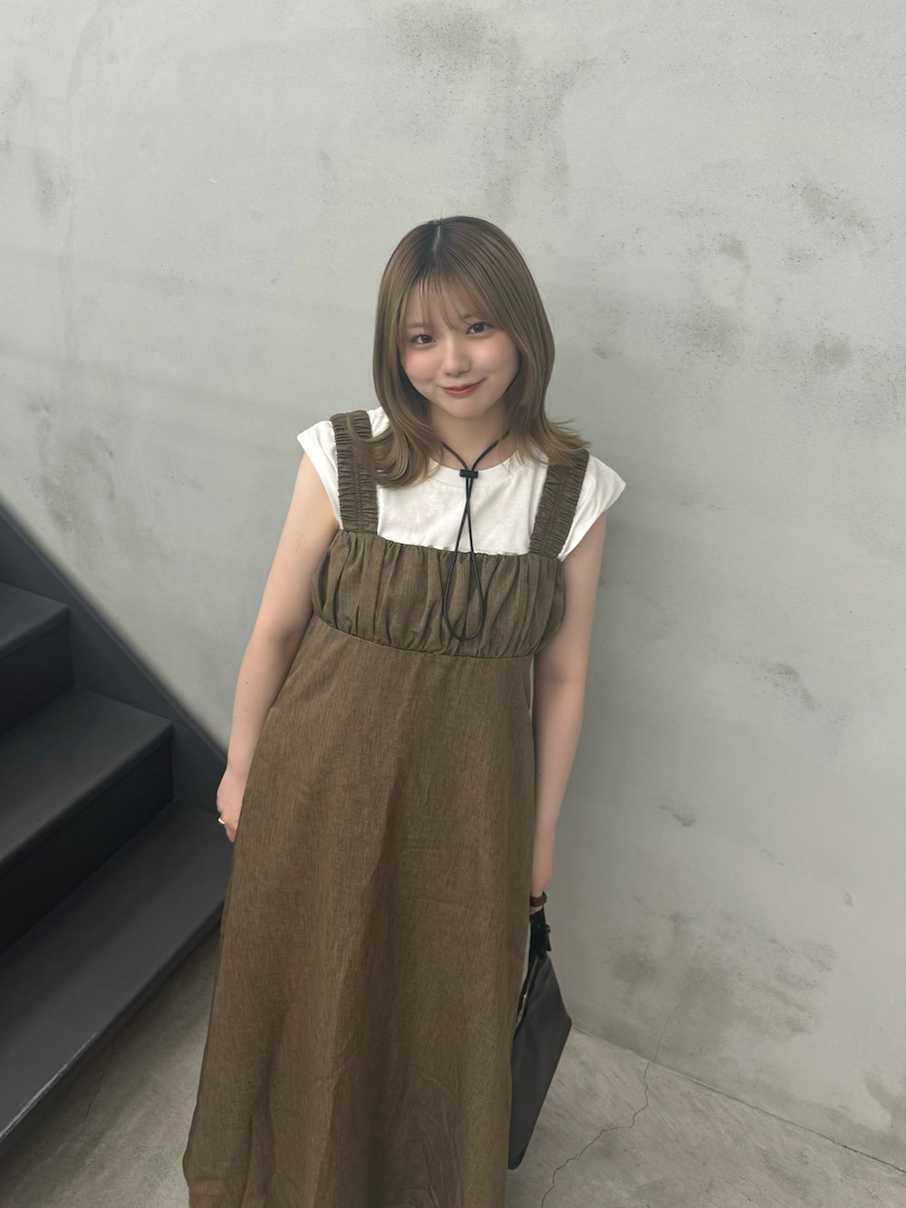 ブラウン系のワンピース、ブラック系のハンドバッグ、ホワイト系のTシャツ/カットソーを着用したレディースの夏コーディネートの5枚目の写真