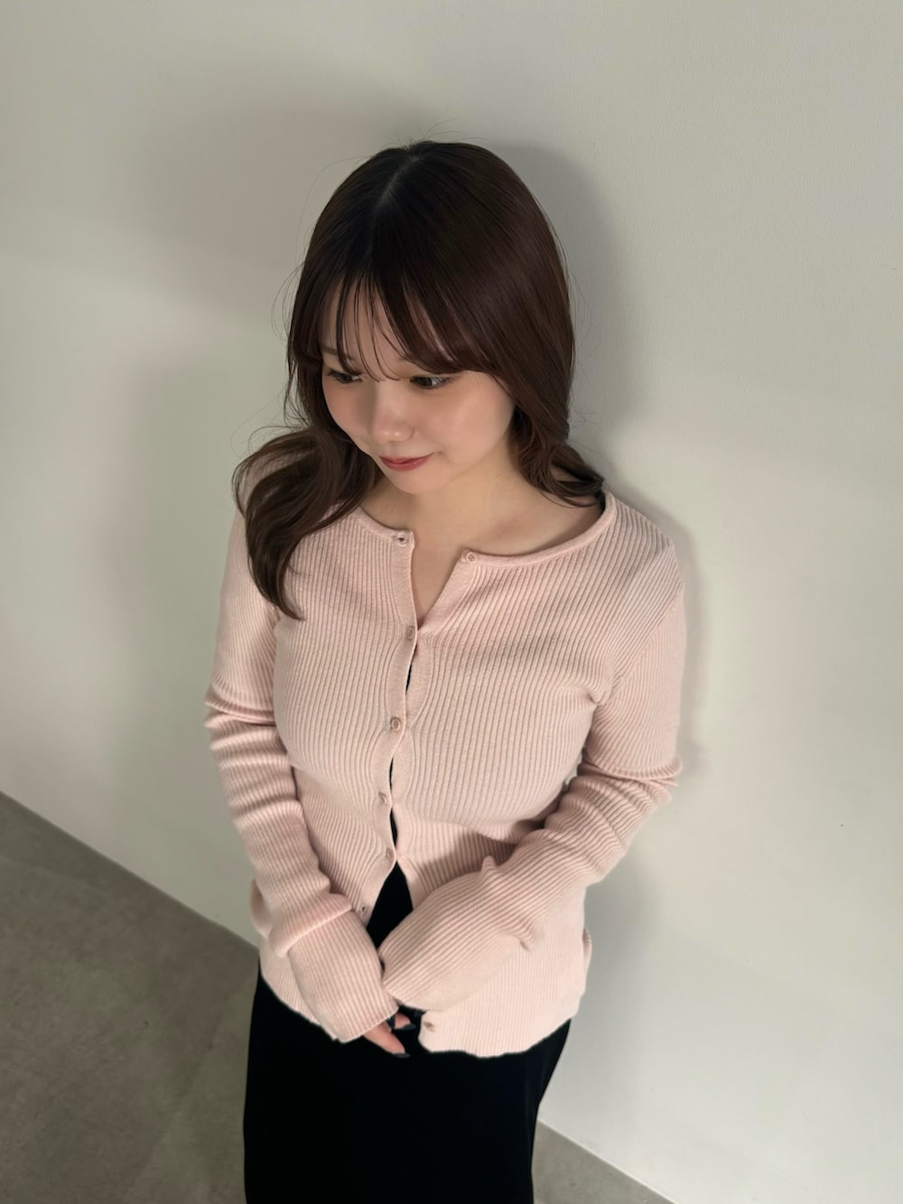 ピンク系のカーディガン/ボレロ、ブラック系のスカート、ブラック系のスリッポンを着用したレディースの冬コーディネートの4枚目の写真