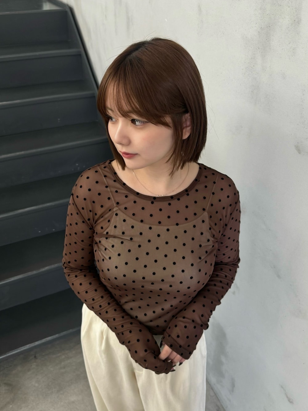 ブラウン系のTシャツ/カットソー、ベージュ系のキャミソール、ホワイト系のスラックスを着用したレディースの秋コーディネートの6枚目の写真