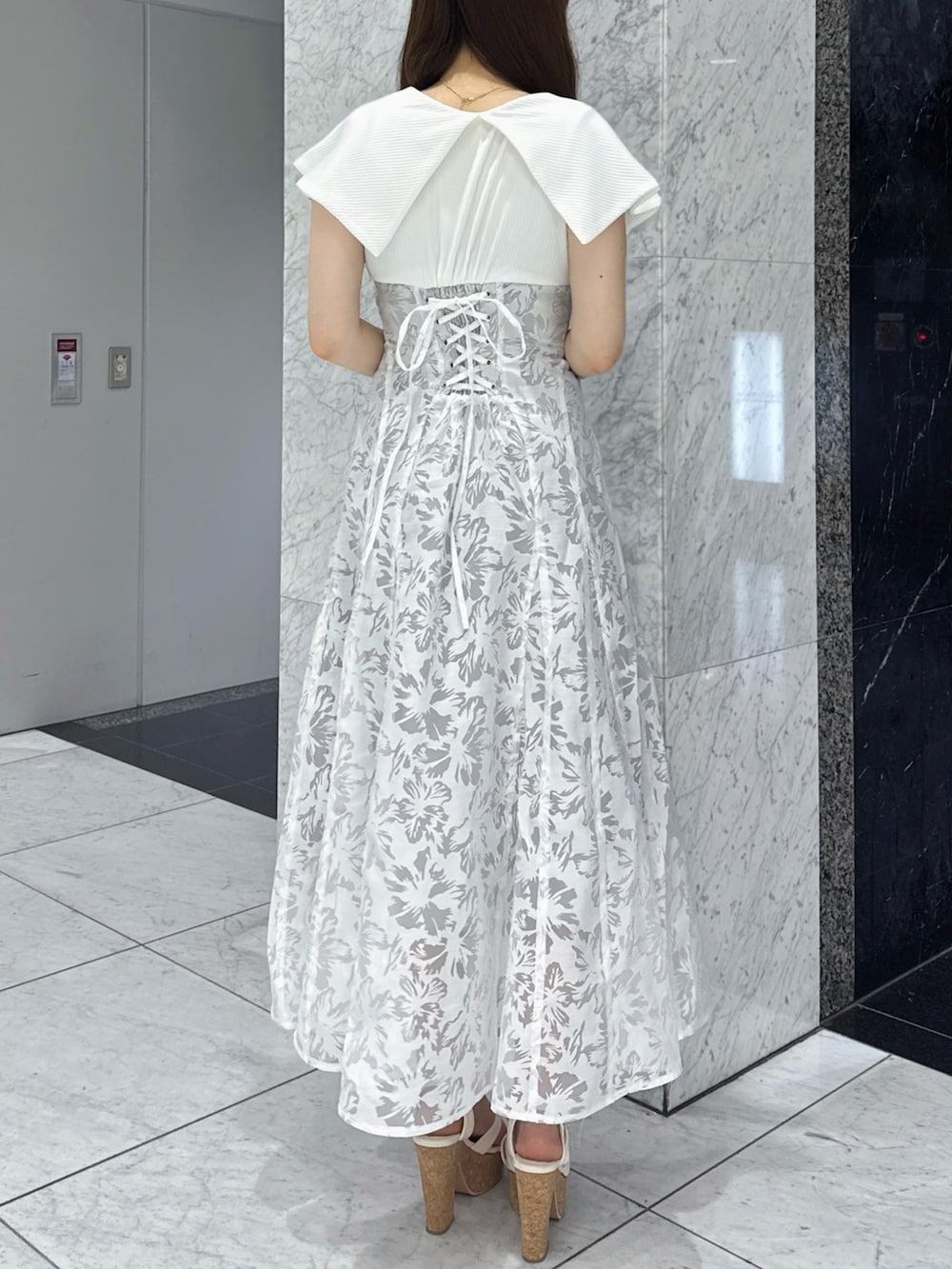 ホワイト系のワンピース、ホワイト系のサンダルを着用したレディースの夏コーディネートの3枚目の写真