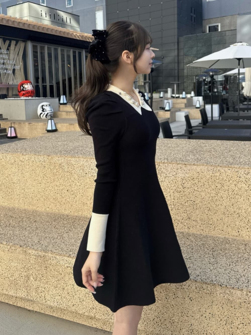 その他のローファー、ブラック系のトレンチコート、ブラック系のワンピースを着用したレディースの秋コーディネートの6枚目の写真