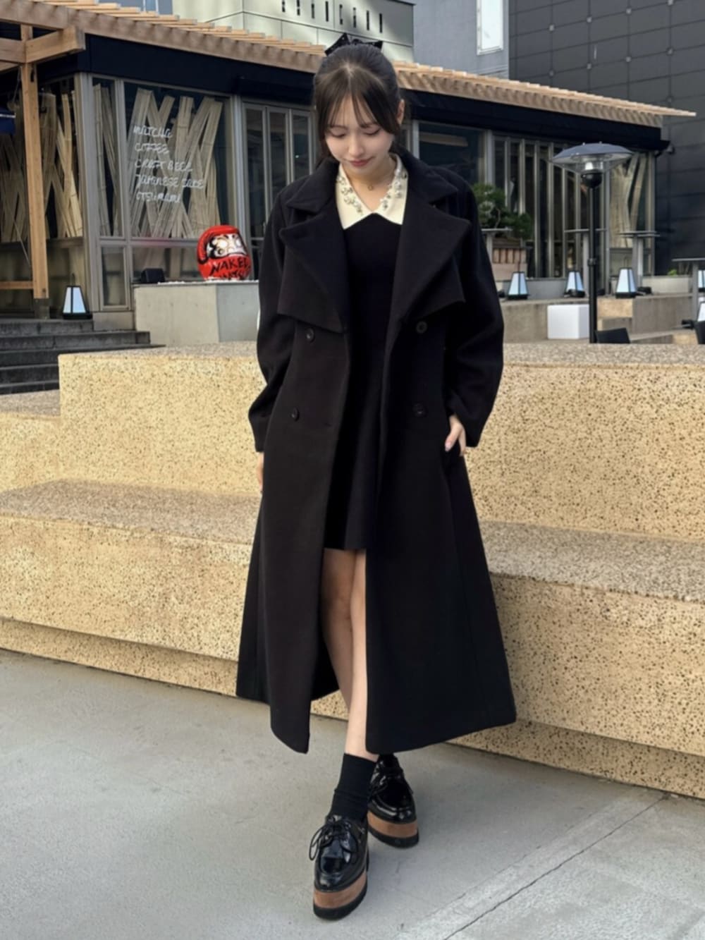 その他のローファー、ブラック系のトレンチコート、ブラック系のワンピースを着用したレディースの秋コーディネートの2枚目の写真