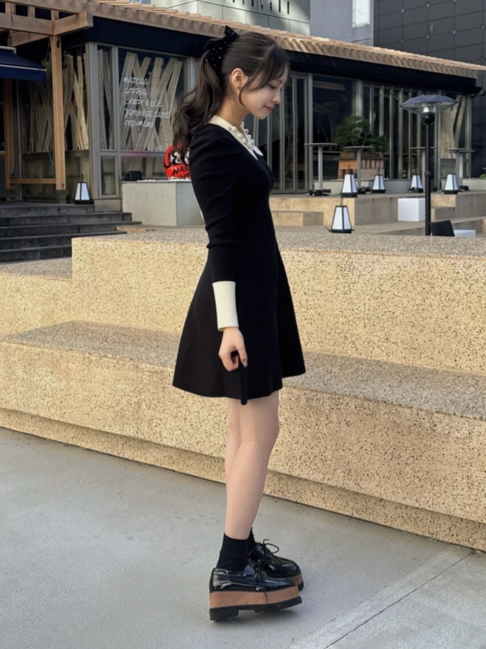 その他のローファー、ブラック系のトレンチコート、ブラック系のワンピースを着用したレディースの秋コーディネートの4枚目の写真