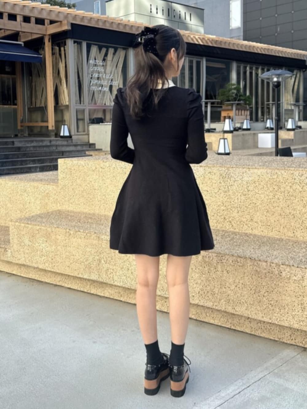 その他のローファー、ブラック系のトレンチコート、ブラック系のワンピースを着用したレディースの秋コーディネートの5枚目の写真