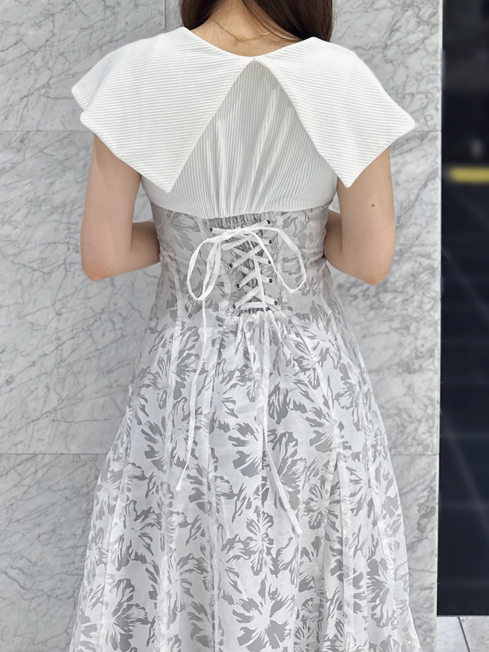 ホワイト系のワンピース、ホワイト系のサンダルを着用したレディースの夏コーディネートの5枚目の写真