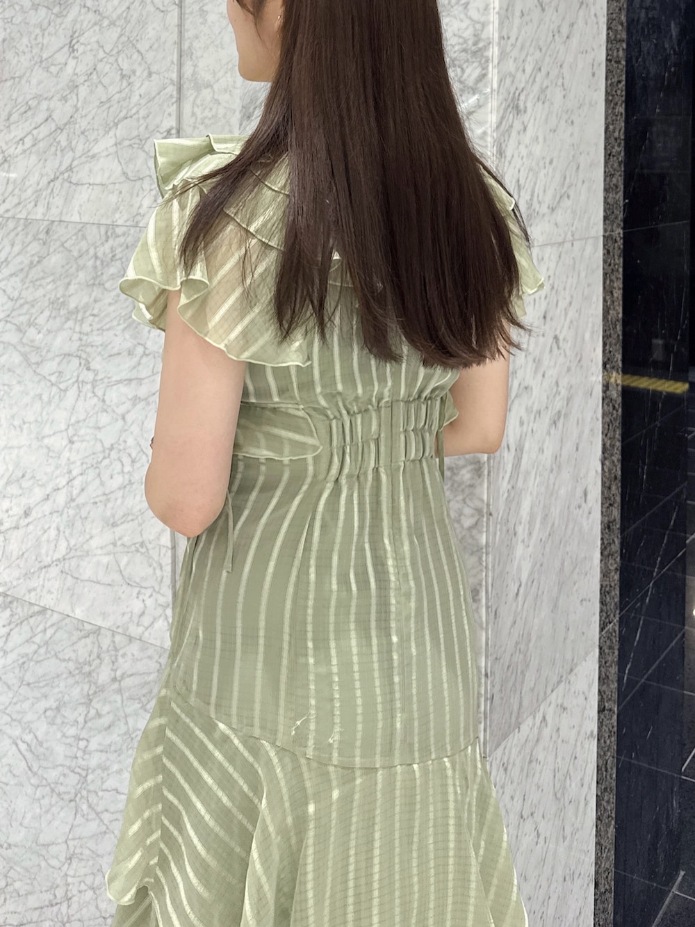 グリーン系のワンピース、ブラウン系のローファーを着用したレディースの春コーディネートの5枚目の写真