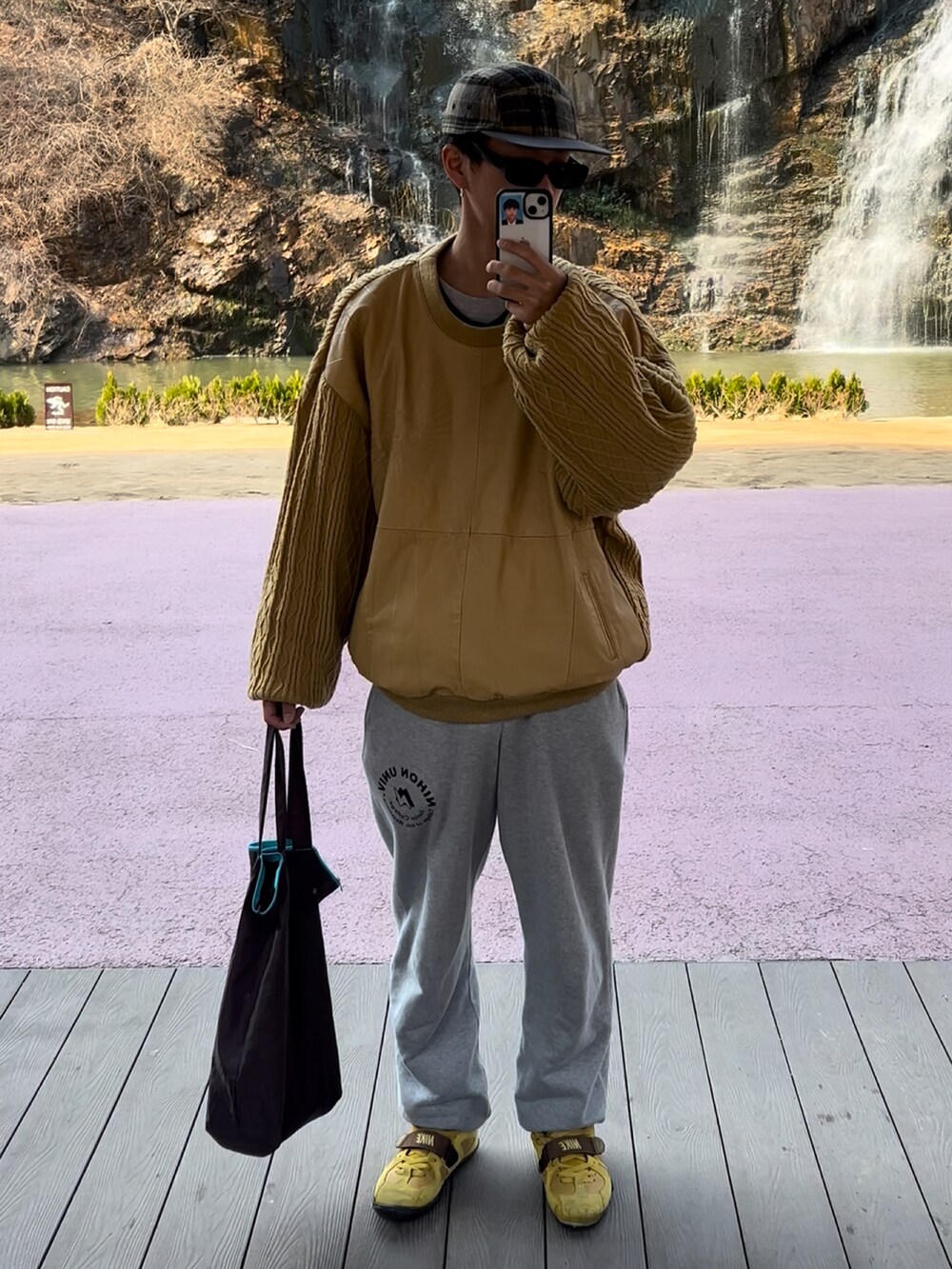 イエロー系のシューズ、イエロー系のニット/セーター、グレー系のスウェットパンツを着用したメンズの春コーディネートの3枚目の写真