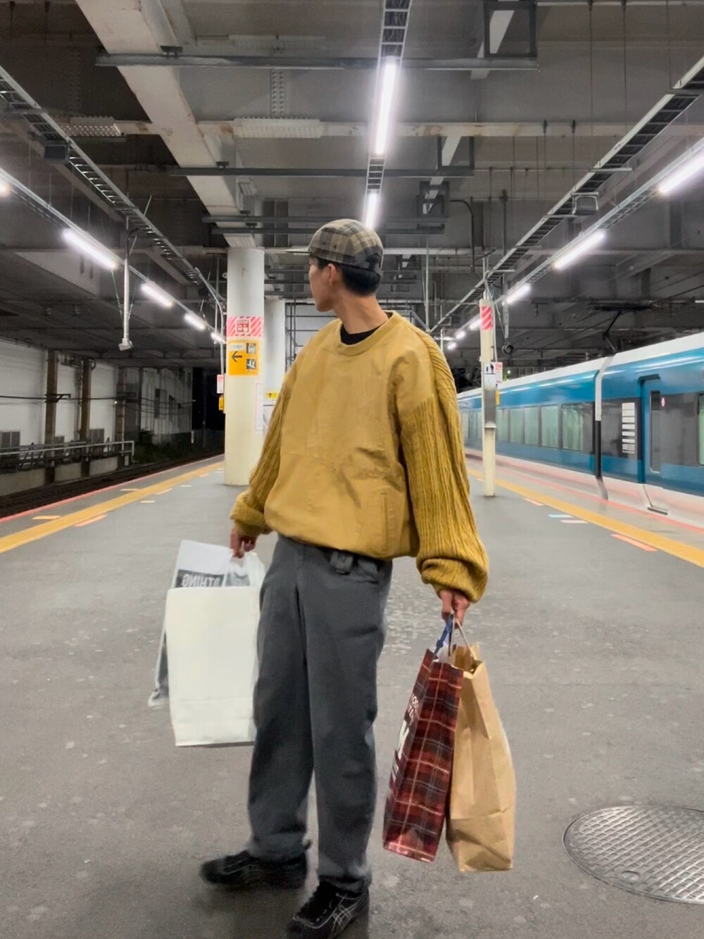 イエロー系のニット/セーター、グレー系のスウェットパンツ、ブラック系のシューズを着用したメンズの春コーディネートの2枚目の写真