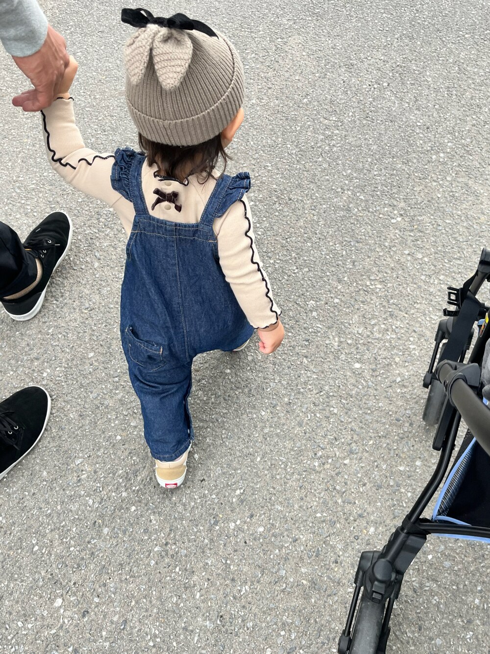 ベージュ系のスニーカー、ブルー系のオールインワン・サロペット、ベージュ系のニットキャップ/ビーニーを着用したキッズの秋コーディネートの2枚目の写真