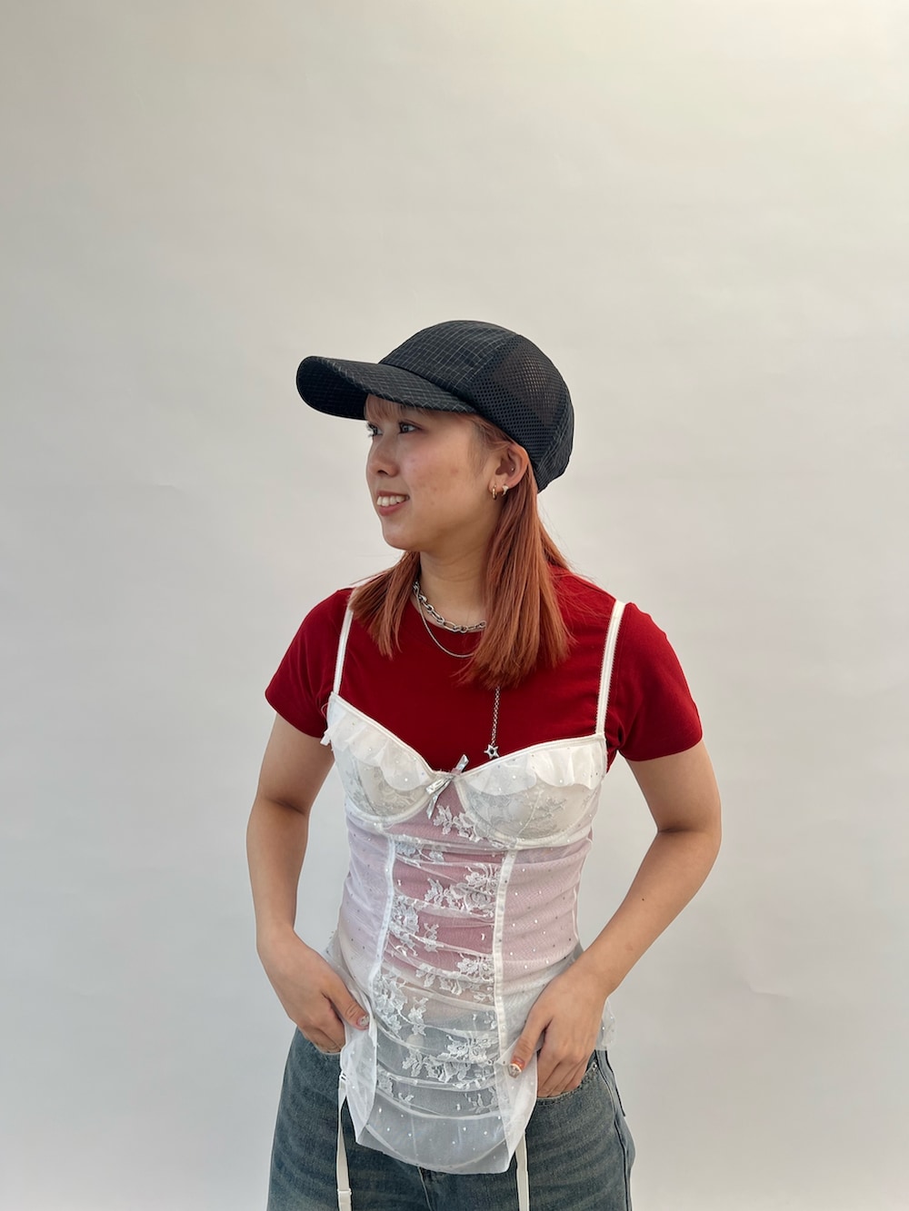レッド系のTシャツ/カットソー、ブラック系のキャップ、グレー系のヘアバンドを着用したレディースの夏コーディネートの4枚目の写真