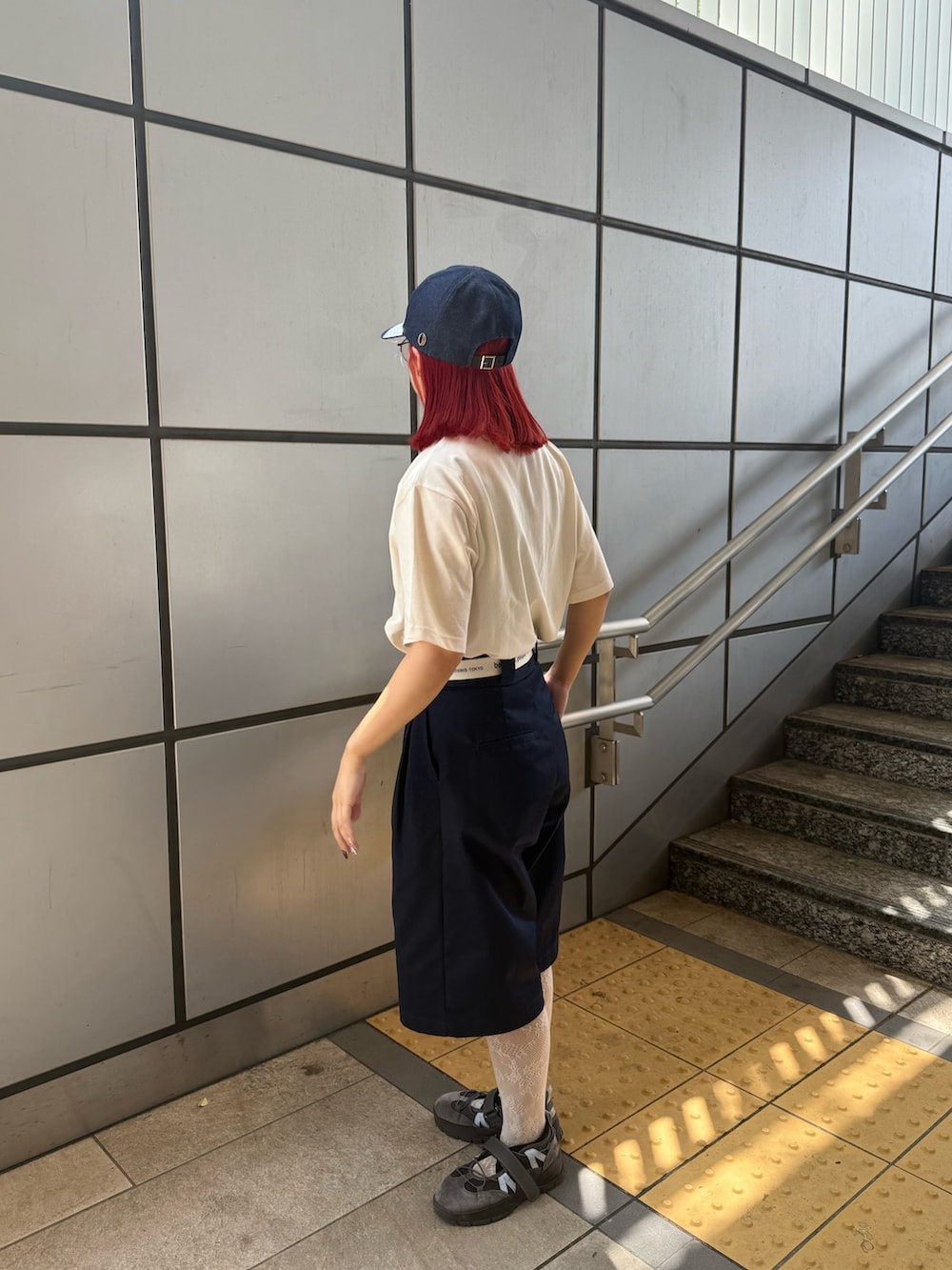 ブルー系のキャップを着用したレディースの夏コーディネートの2枚目の写真
