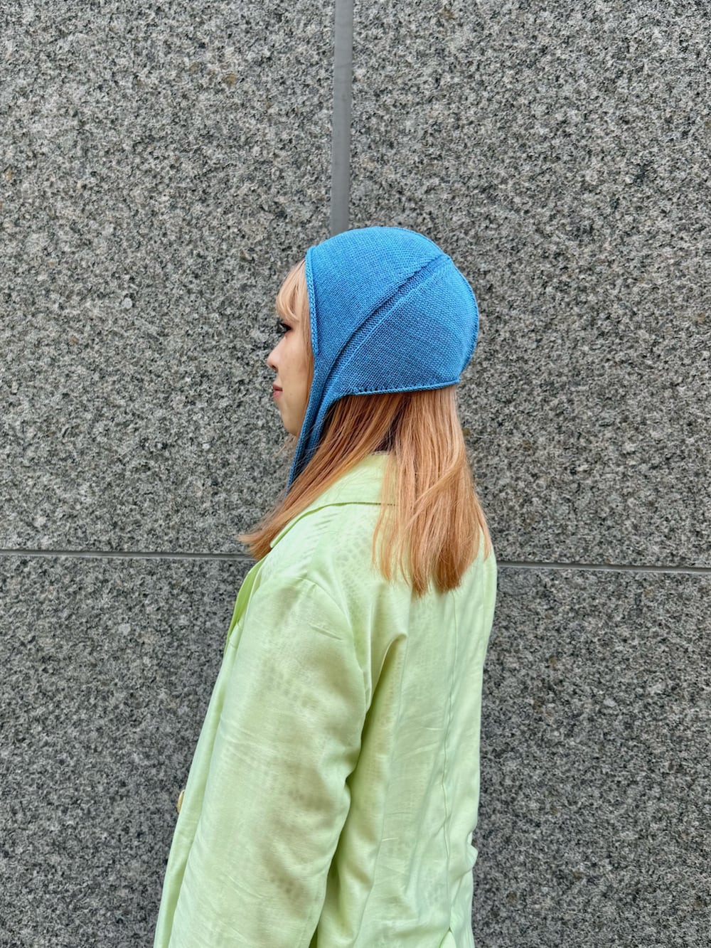 グリーン系のテーラードジャケット、ブルー系のハットを着用したレディースの夏コーディネートの4枚目の写真