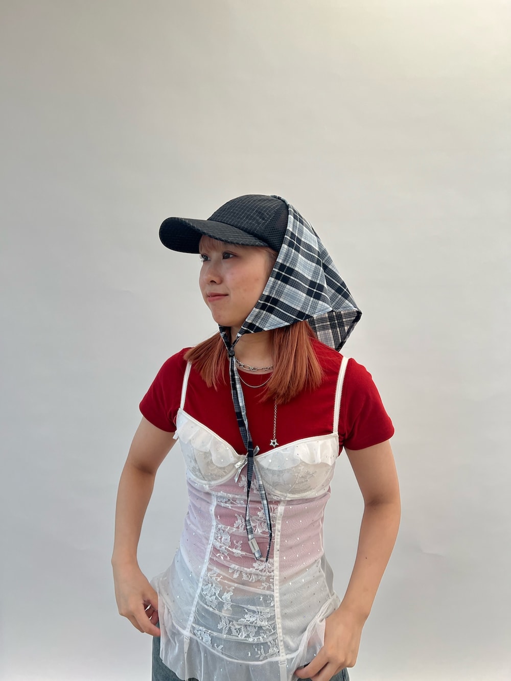 レッド系のTシャツ/カットソー、ブラック系のキャップ、グレー系のヘアバンドを着用したレディースの夏コーディネートの3枚目の写真