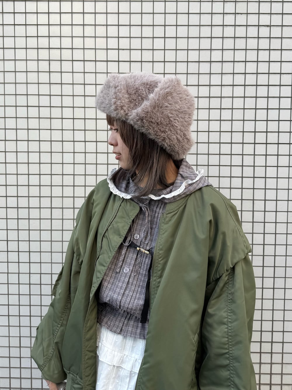 ブラウン系のシャツ/ブラウス、グリーン系のMA-1、シルバー系のハンドバッグを着用したレディースの秋コーディネートの4枚目の写真