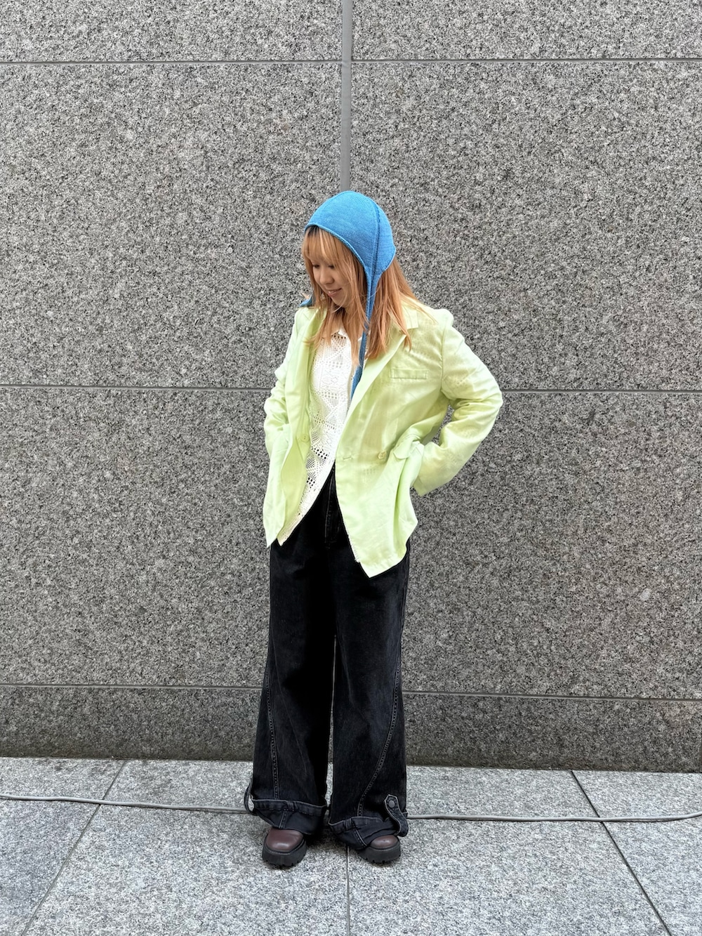 グリーン系のテーラードジャケット、ブルー系のハットを着用したレディースの夏コーディネートの2枚目の写真