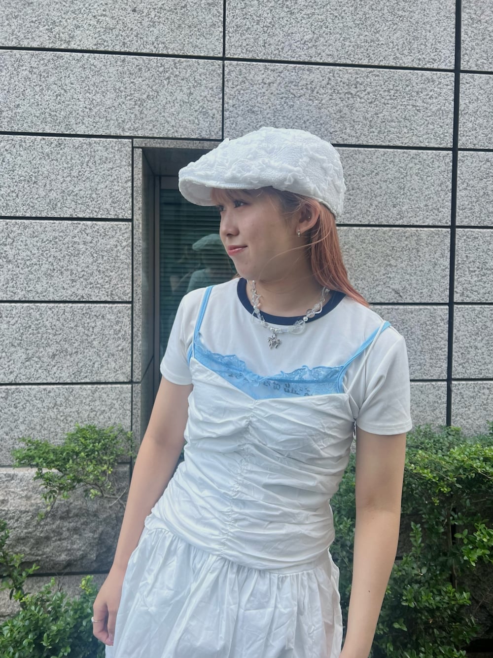 ブルー系のデニムパンツ、グレー系のスニーカー、ホワイト系のハンチング/ベレー帽を着用したレディースの夏コーディネートの3枚目の写真