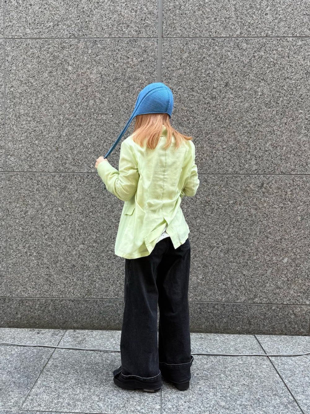 グリーン系のテーラードジャケット、ブルー系のハットを着用したレディースの夏コーディネートの3枚目の写真