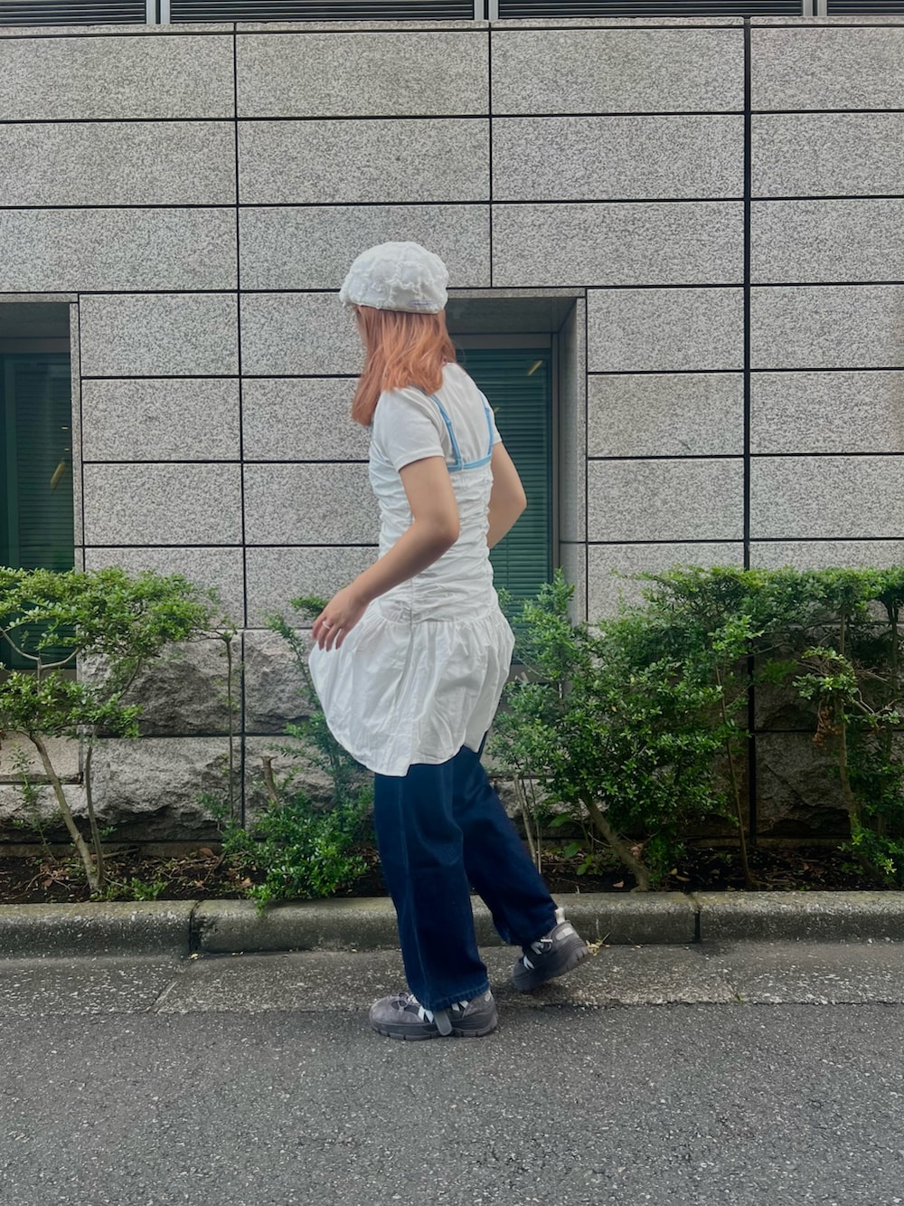 ブルー系のデニムパンツ、グレー系のスニーカー、ホワイト系のハンチング/ベレー帽を着用したレディースの夏コーディネートの2枚目の写真