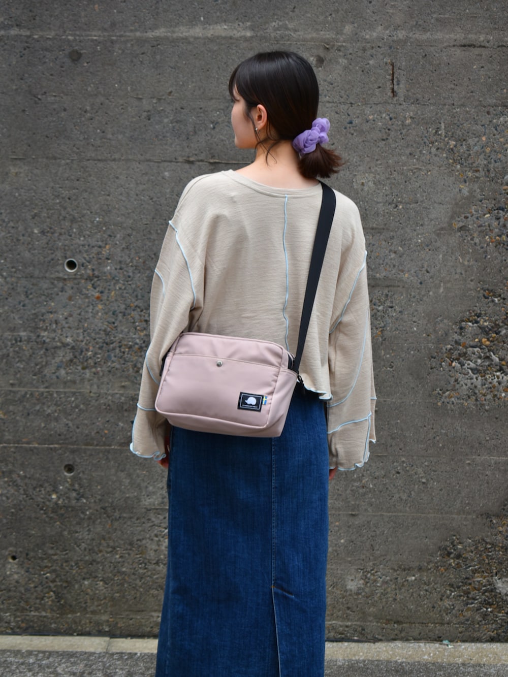 ピンク系のショルダーバッグ、ベージュ系のTシャツ/カットソーを着用したレディースの秋コーディネートの4枚目の写真