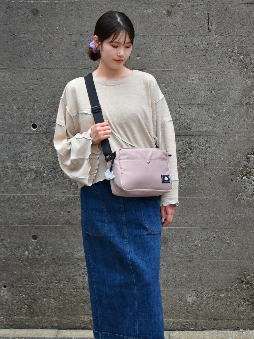 ピンク系のショルダーバッグ、ベージュ系のTシャツ/カットソーを着用したレディースの秋コーディネートの3枚目の写真