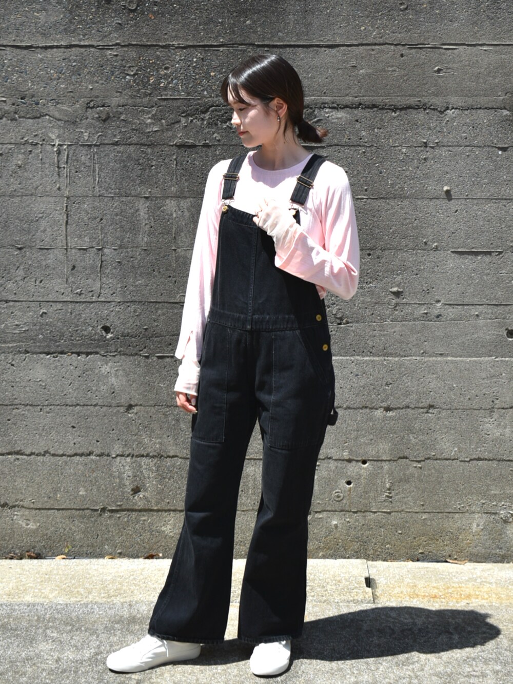ピンク系のTシャツ/カットソー、ブラック系のハットを着用したレディースの秋コーディネートの2枚目の写真