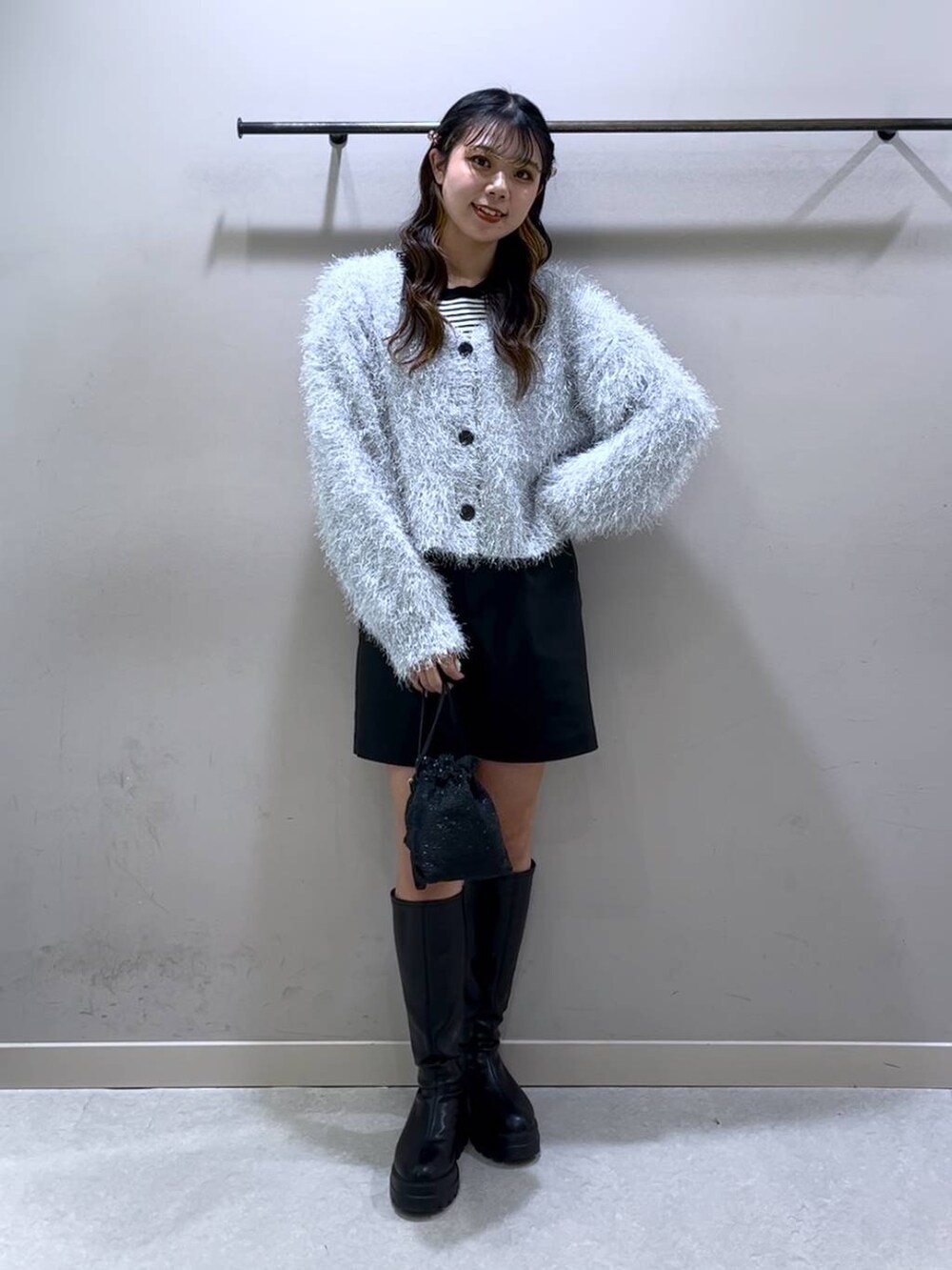 ブラック系のニット/セーター、ブラック系のブーツ、ブラック系のショルダーバッグを着用したレディースの冬コーディネートの9枚目の写真