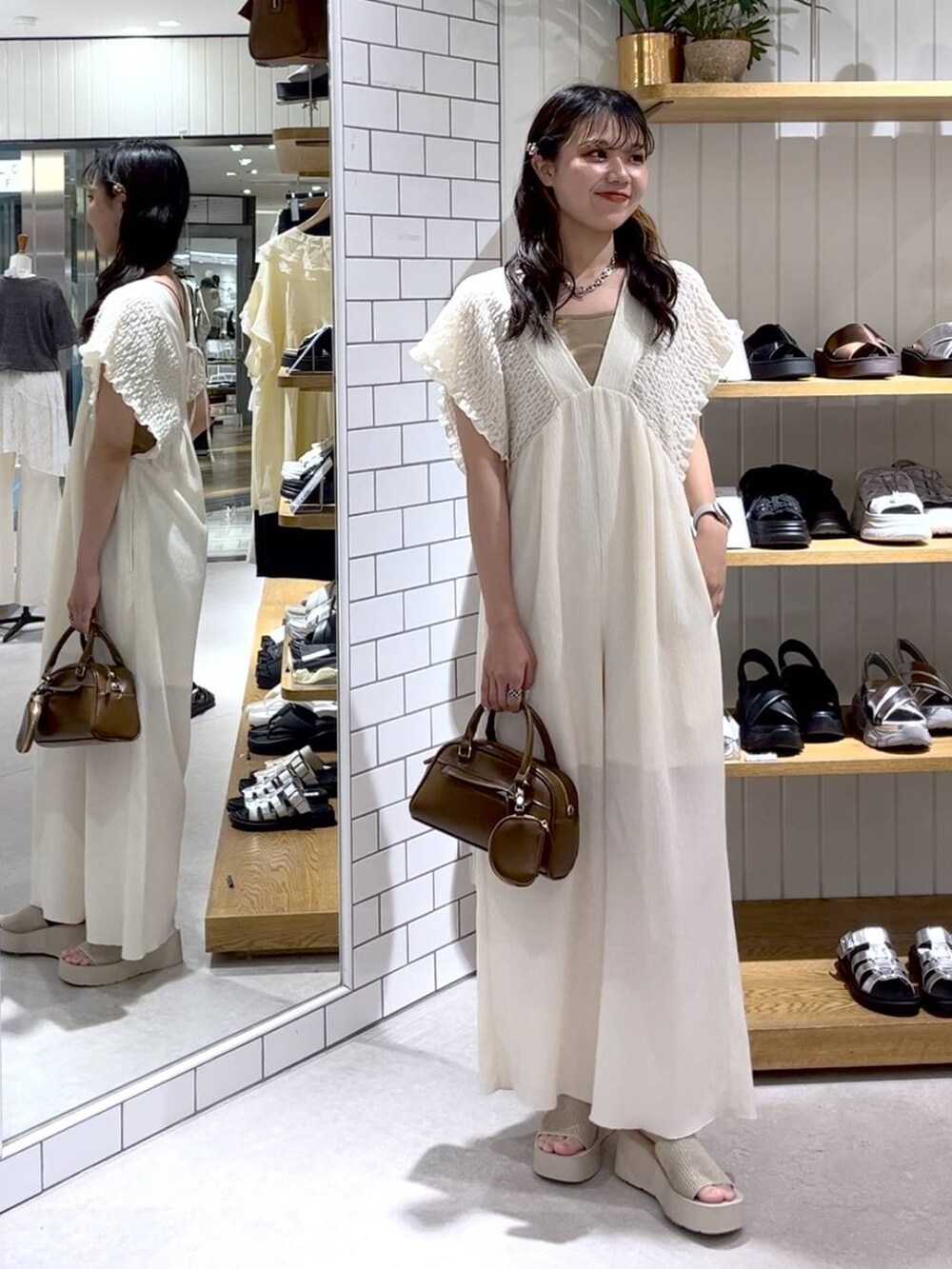 ベージュ系のTシャツ/カットソー、ホワイト系のサンダル、ホワイト系のサロペット/オーバーオールを着用したレディースの夏コーディネートの5枚目の写真