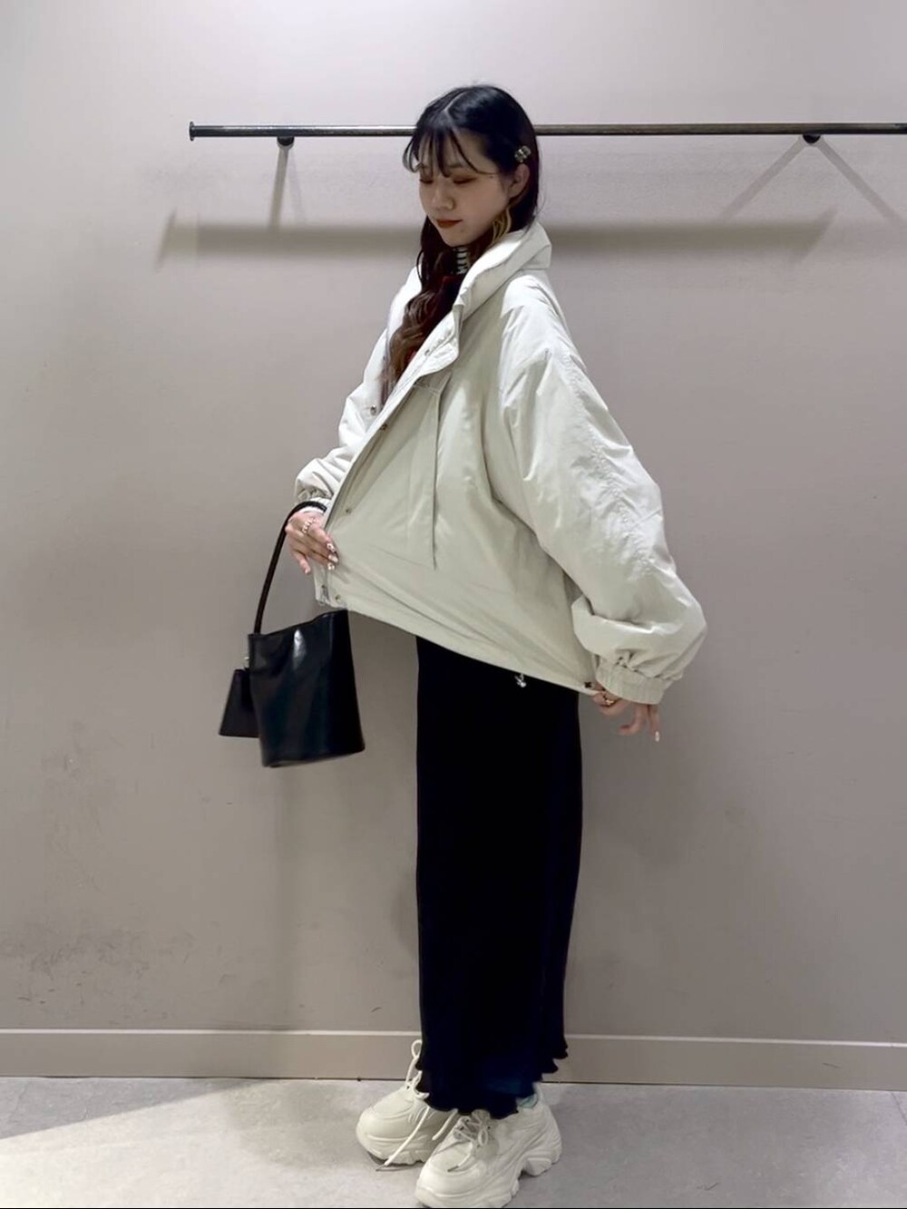 レッド系のニット/セーター、ホワイト系のその他アウター、ブラック系のスカートを着用したレディースの冬コーディネートの7枚目の写真