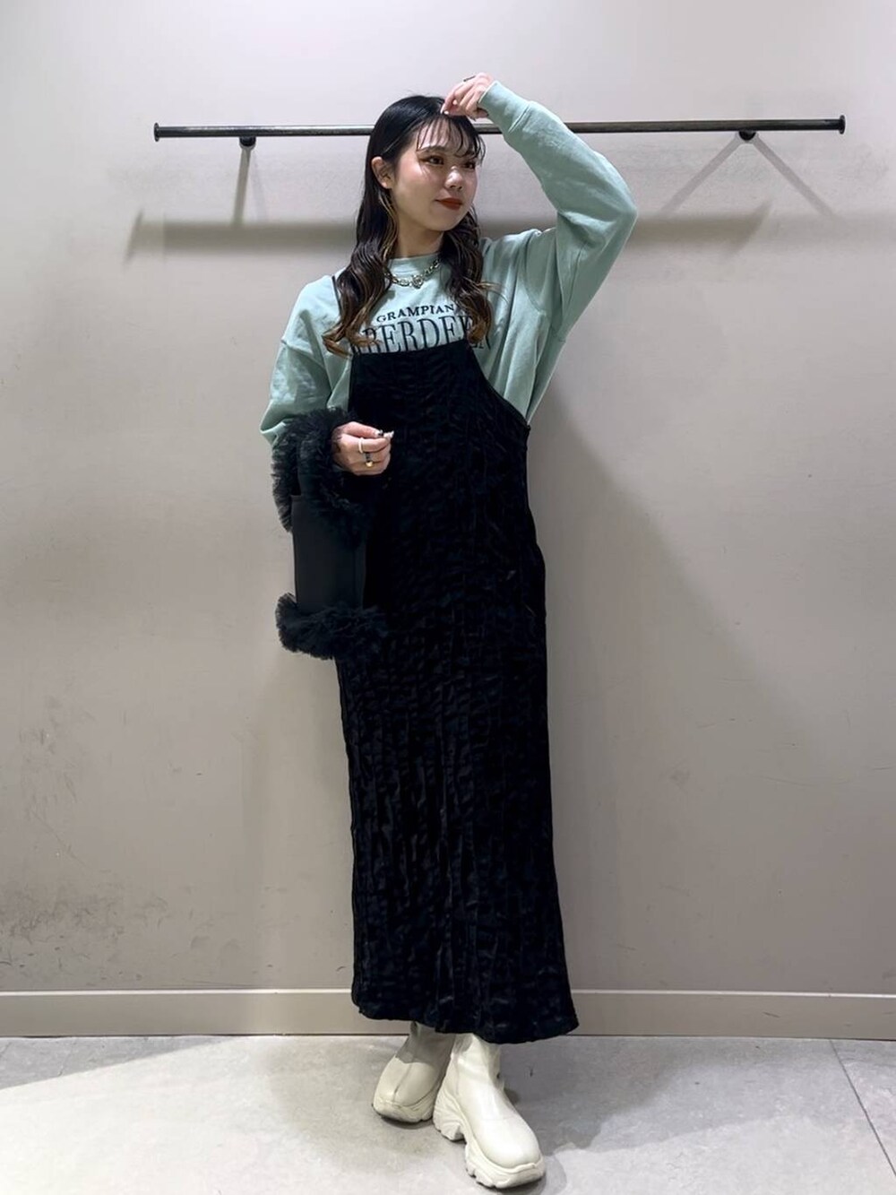 ホワイト系のブーツ、グリーン系のスウェット、ブラック系のワンピースを着用したレディースの冬コーディネートの7枚目の写真