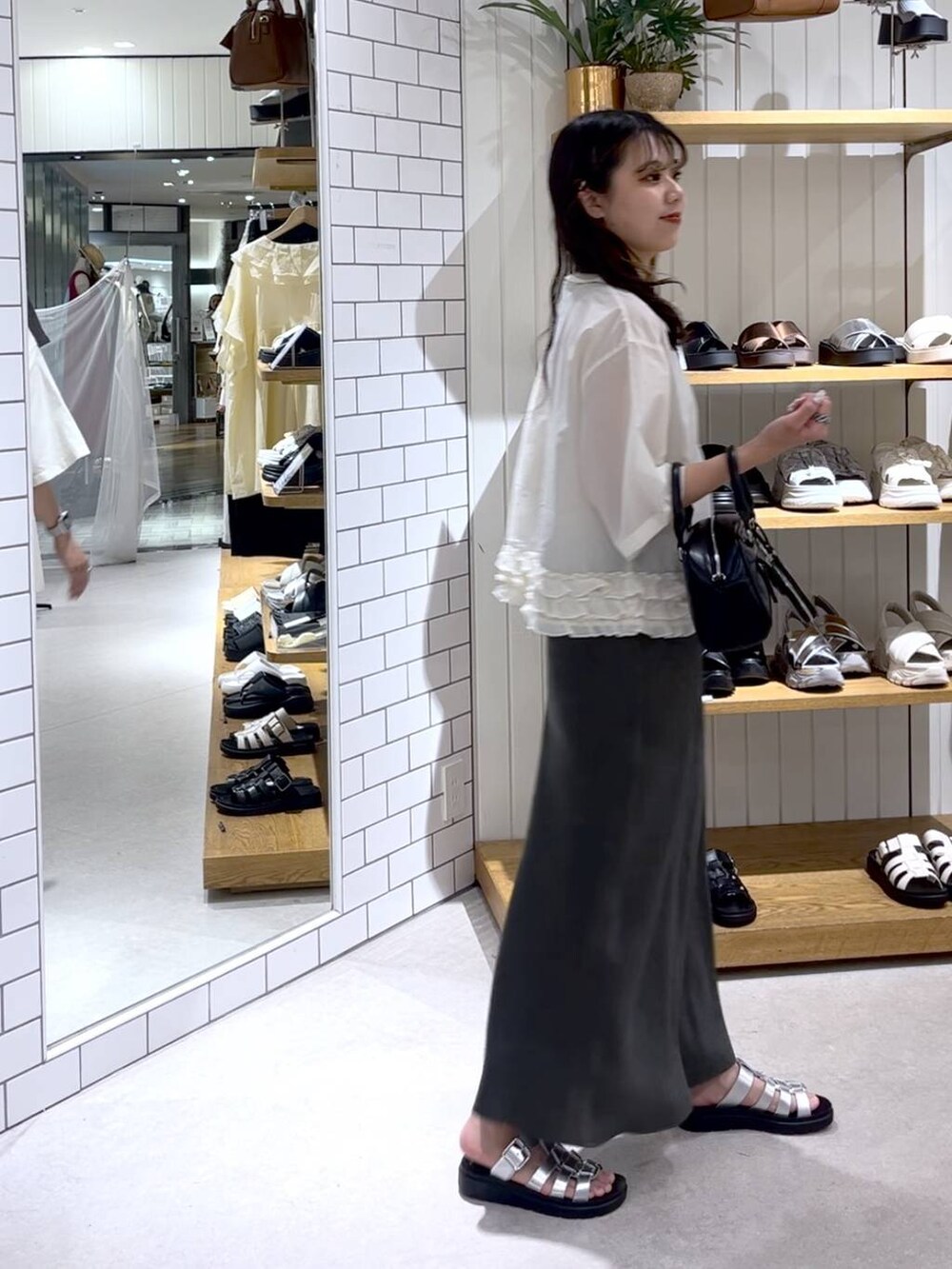 ベージュ系のTシャツ/カットソー、グレー系のスカート、シルバー系のサンダルを着用したレディースの夏コーディネートの5枚目の写真