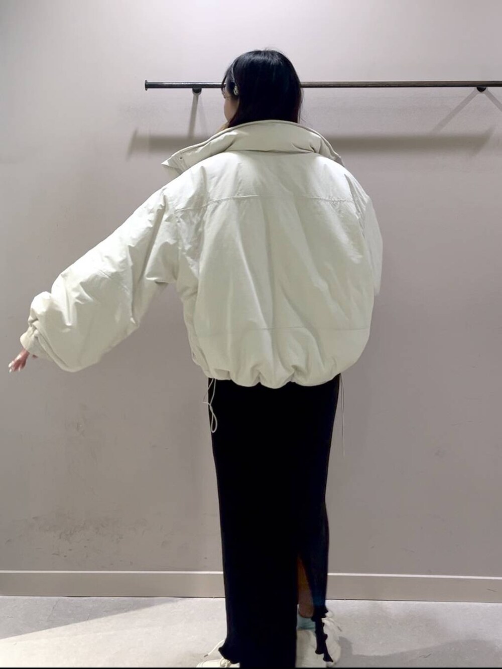 レッド系のニット/セーター、ホワイト系のその他アウター、ブラック系のスカートを着用したレディースの冬コーディネートの3枚目の写真