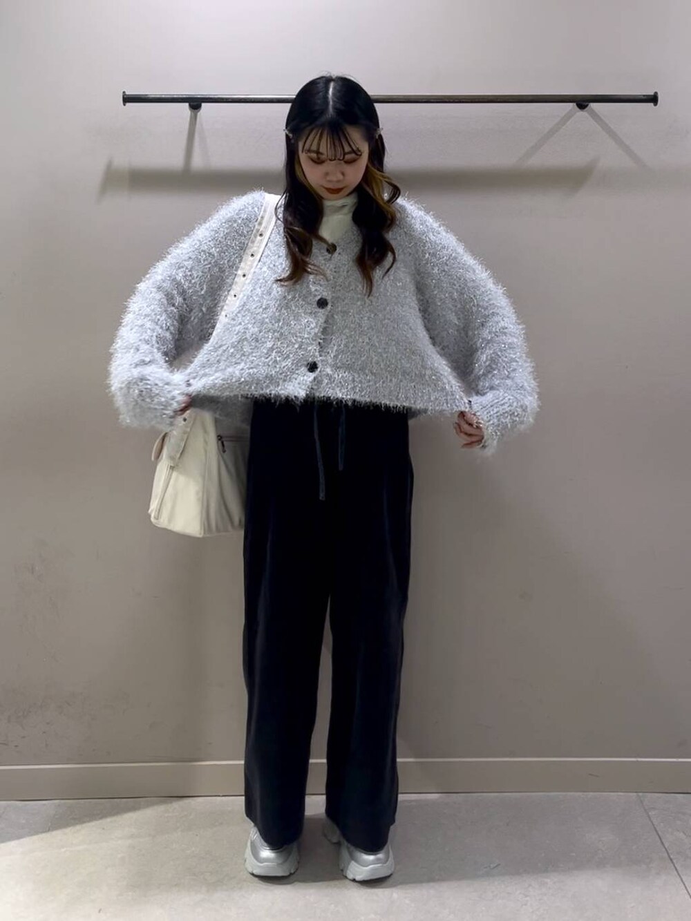 ホワイト系のショルダーバッグ、ホワイト系のTシャツ/カットソー、シルバー系のスニーカーを着用したレディースの冬コーディネートの6枚目の写真