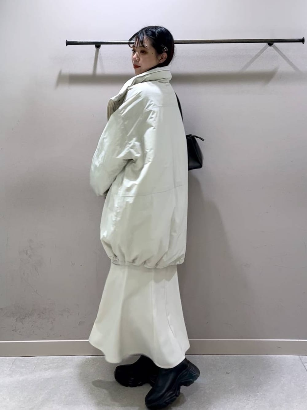 ホワイト系のその他アウター、ブラック系のブーツ、ホワイト系のスカートを着用したレディースの冬コーディネートの6枚目の写真