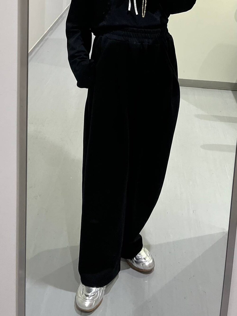 ブラック系のスウェットパンツ、シルバー系のスニーカー、ブラック系のTシャツ/カットソーを着用したレディースの秋コーディネートの3枚目の写真