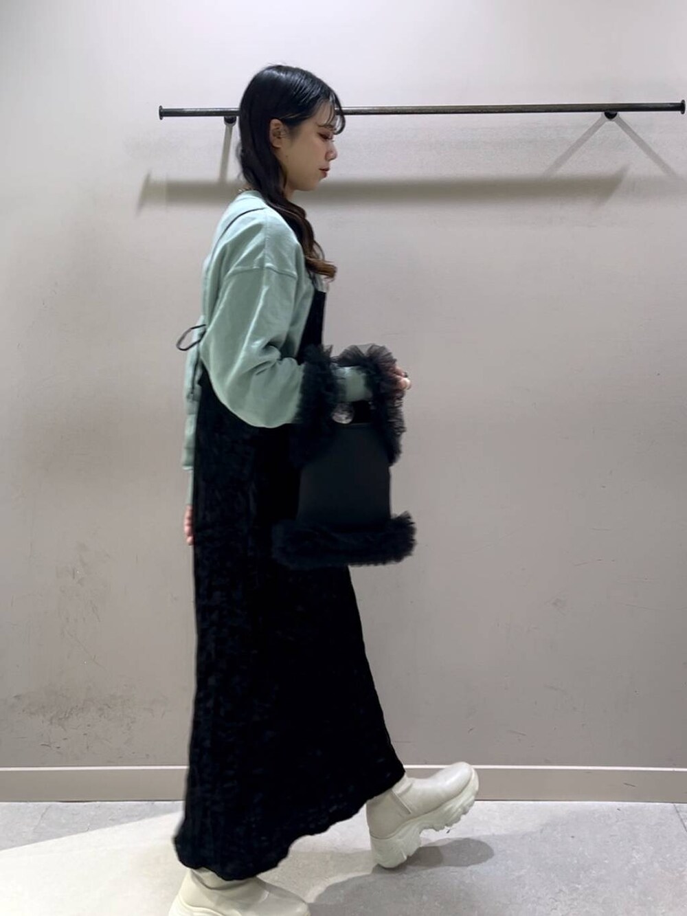 ホワイト系のブーツ、グリーン系のスウェット、ブラック系のワンピースを着用したレディースの冬コーディネートの4枚目の写真