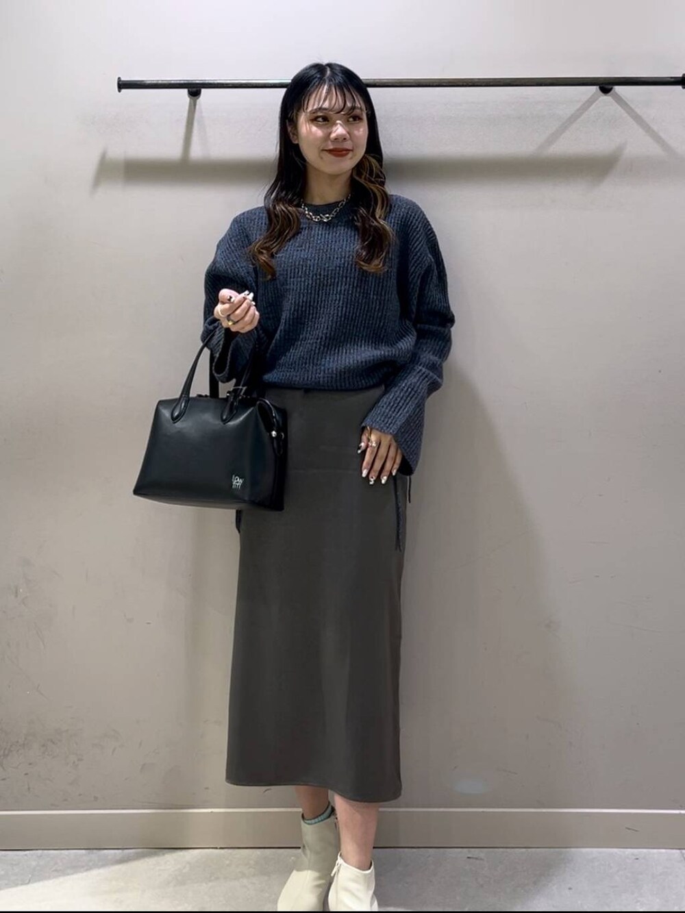 ブルー系のワンピース、ブラック系のショルダーバッグ、ホワイト系のブーツを着用したレディースの冬コーディネートの6枚目の写真