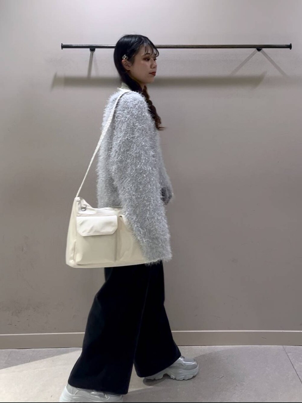 ホワイト系のショルダーバッグ、ホワイト系のTシャツ/カットソー、シルバー系のスニーカーを着用したレディースの冬コーディネートの4枚目の写真