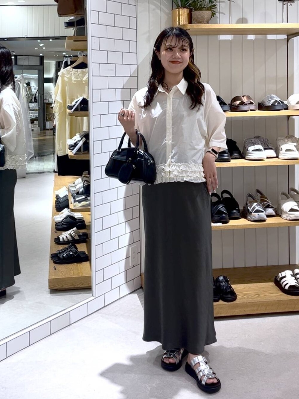 ベージュ系のTシャツ/カットソー、グレー系のスカート、シルバー系のサンダルを着用したレディースの夏コーディネートの6枚目の写真