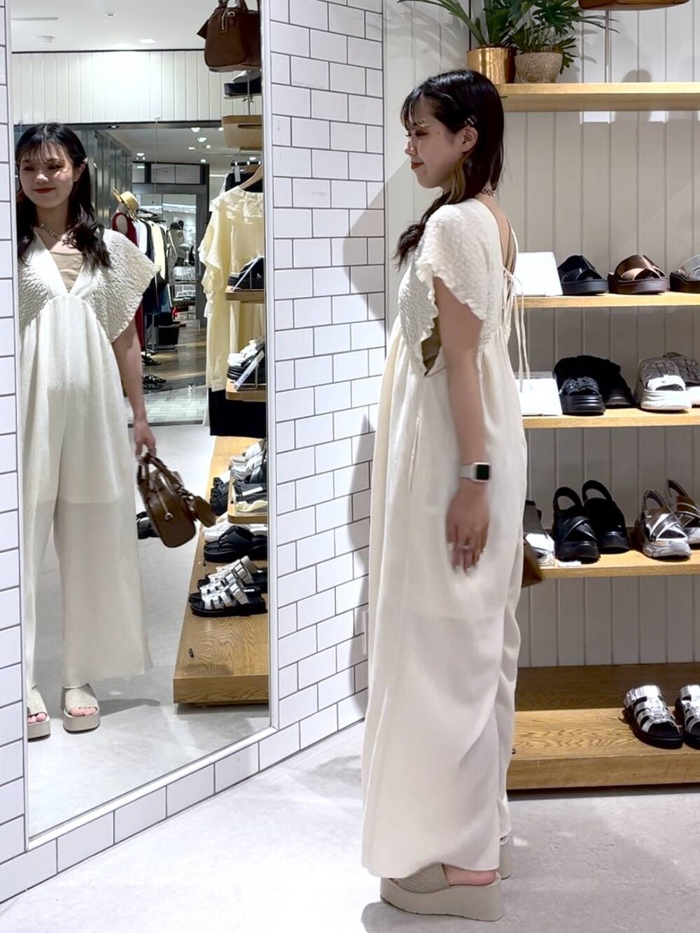 ベージュ系のTシャツ/カットソー、ホワイト系のサンダル、ホワイト系のサロペット/オーバーオールを着用したレディースの夏コーディネートの2枚目の写真